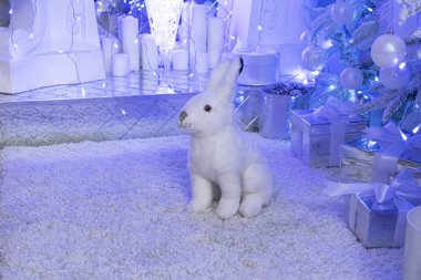 Noel ağacı arka planında bir tavşan. Noel süsleri. Yeni yıl. Noel ağacının altında tatil hediyeleri.