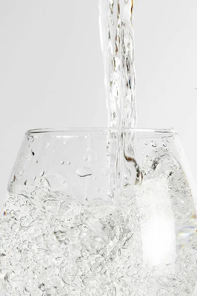 Wasser in Glas gegossen, isoliert auf weißem Hintergrund — Stockfoto