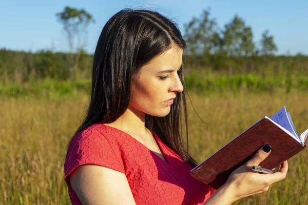 Chica caucásica con un cuaderno sobre la naturaleza — Foto de Stock