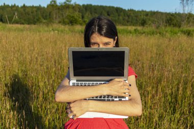 Doğada dizüstü bilgisayarı olan beyaz bir kız. Kopyalama alanı