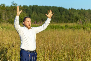 Mavi takım elbiseli beyaz adam öfkeyle ellerini kaldırdı.