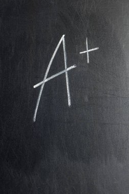 Tebeşir tahtasına A + olarak yazılmış