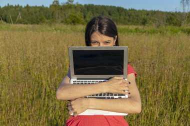 Doğada dizüstü bilgisayarı olan beyaz bir kız. Kopyalama alanı