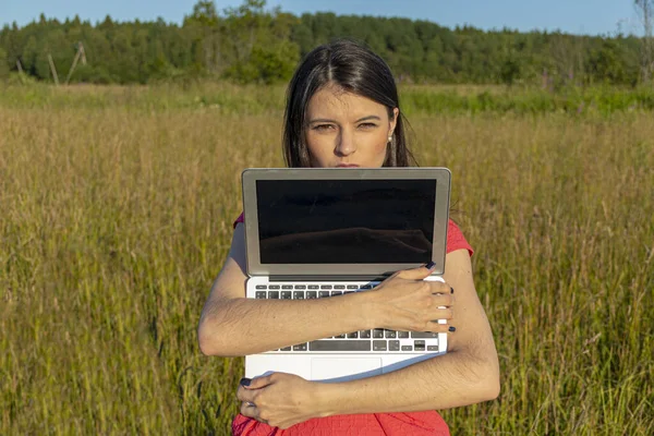 Doğada dizüstü bilgisayarı olan beyaz bir kız. Kopyalama alanı