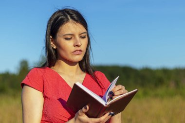 Doğayla ilgili bir defteri olan beyaz bir kız.