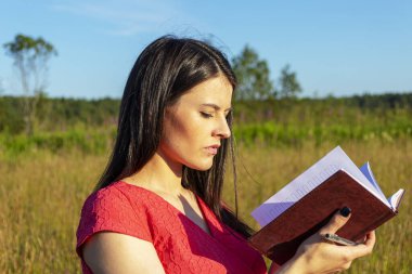 Doğayla ilgili bir defteri olan beyaz bir kız.