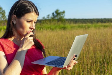 Doğada dizüstü bilgisayarı olan beyaz bir kız. Kopyalama alanı