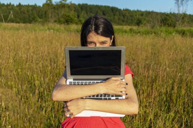 Doğada dizüstü bilgisayarı olan beyaz bir kız. Kopyalama alanı