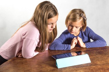bir tablet bilgisayar aygıt üzerinde oynayan kızlar