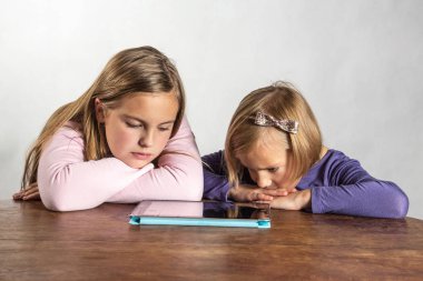 bir tablet bilgisayar aygıt üzerinde oynayan kızlar