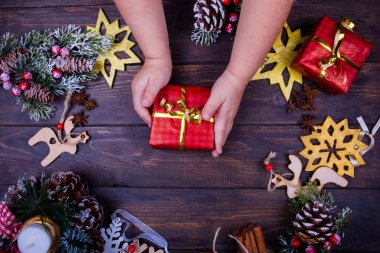 Sezon dekorasyon ile çerçeveli Noel ve yeni yıl ahşap arka plan. Kış tatil Tema. Bir hediye bebek el ele tutuşur