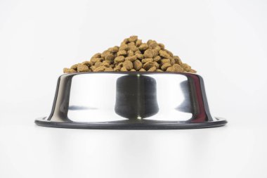 Beyaz arka plan üzerinde izole metal bir kase içinde üç yemekleri kuru evde beslenen hayvan yiyecek kümesi. Üst, yarısı ve ön göster