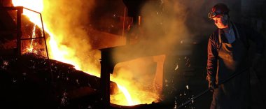 Dökümhanede sıvı metal, fırında eritme demiri, çelik fabrikası. Gözlüklü ve miğferli işçiler ocaklarda demir eritmeyi kontrol ediyorlar. Temel bir metali çıkarmak için madenlere ısı uyguluyorlar.