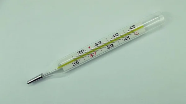 O termômetro em um fundo leve . — Fotografia de Stock