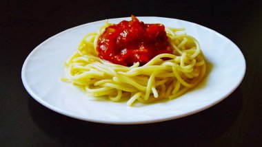 Beyaz bir tabakta sebze ile lezzetli makarna.