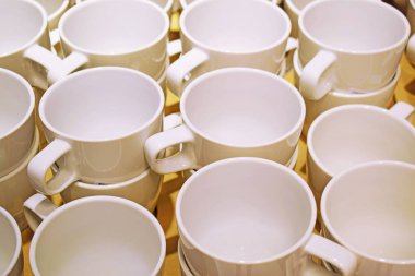 Rafta bir yığın boş beyaz çay fincanı..