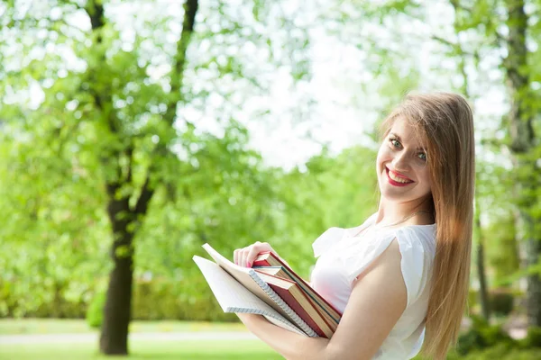 Estudante menina com montão de livros — Fotografia de Stock