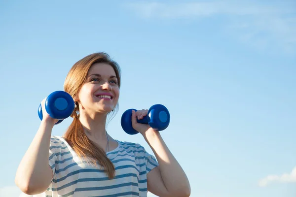Smiling woman with dumbbells — Stock Photo, Image