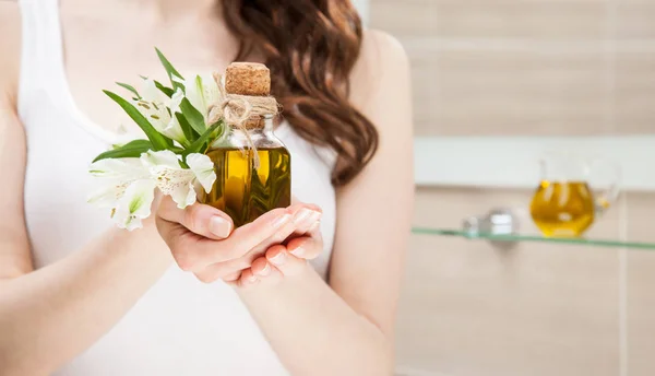 Жінка тримає пляшку натуральної оливкової олії — стокове фото