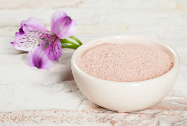 Bowl with pink clay powder and flower — Stock Photo, Image