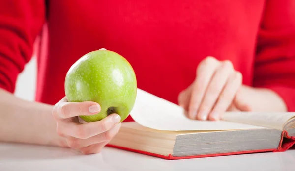 Mulher com livro e maçã — Fotografia de Stock