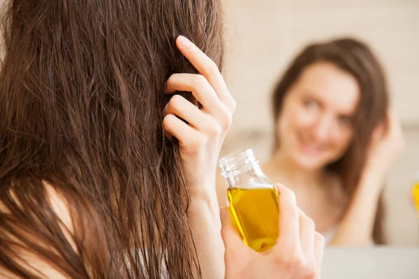Mujer aplicando mascarilla de aceite en el cabello — Foto de Stock
