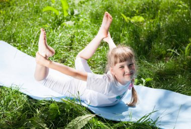 Küçük kız parkta egzersizleri yapıyor