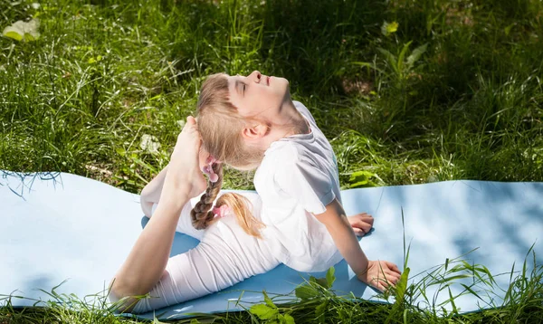 Little girl doing exercises in park — Stock Photo, Image