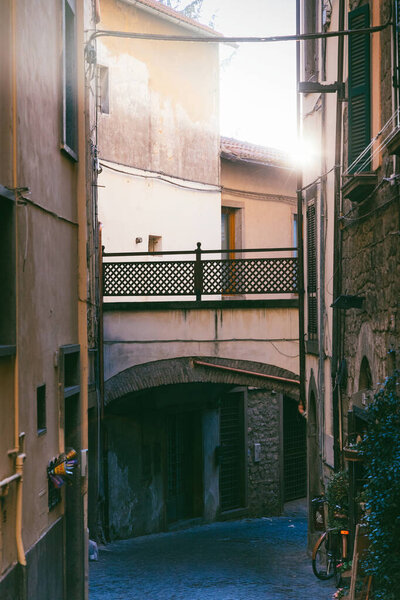 Typical italian narrow street with huge differential in lighting - from bright sun to deep darkness. Viterbo, Italy