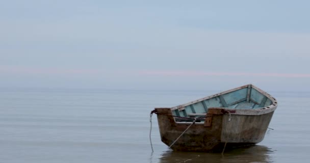 Sakin denizin üzerinde, ön planda tekne olan yumuşak mavi gökyüzünün ilahi bir resmi. — Stok video
