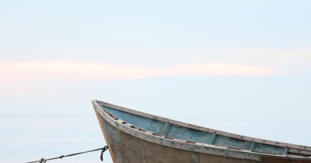 Yumuşak mavi gökyüzünün sakin denizin üzerinde ön planda tekneyle görülebileceği hoş bir manzara. — Stok video