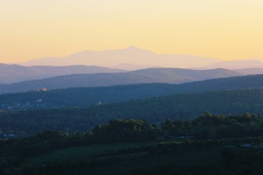 Viyana 'nın etrafındaki tepelerin üstündeki gökyüzü manzaralı gün batımı