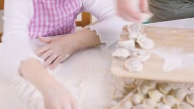 Bir çocuk büyükannesine tahtadan hamur tatlısı toplaması için yardım eder.