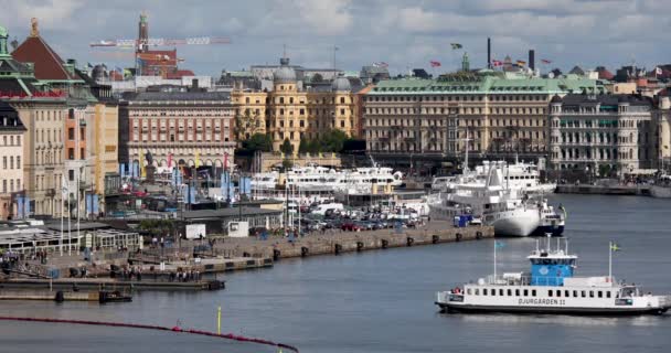 Stockholmská městská krajina. Pohled na promenádu Gamla Stan se spoustou lidí a lodí — Stock video