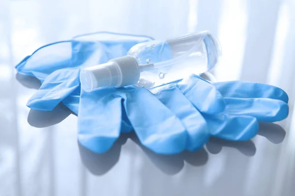 Disposable medical gloves and hand sanitizer — Stock Photo, Image