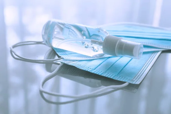 Disposable medical masks and hand sanitizer — Stock Photo, Image