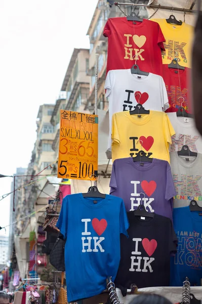 "Ik hou van HK "t-shirts opknoping op een souvenir kraam op de Ladies Market in de regio Mong Kok van Kowloon, Hong Kong — Stockfoto