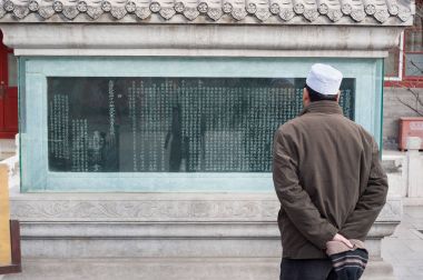 Adam Niujie Camii, Pekin, Çin, antik bir stel üzerinde bir yazıt okur