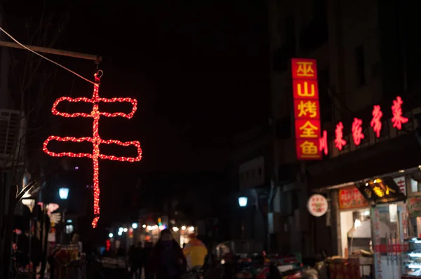 Símbolo chino para kebab (chuan) mostrado como un letrero de neón rojo fuera de un restaurante en una calle de Beijing — Foto de Stock