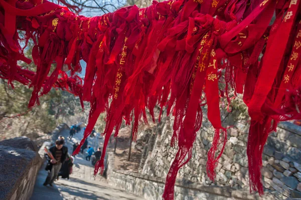 Red ribbons attached to an overhanging branch on the route up Tai Shan, China — Stock Photo, Image