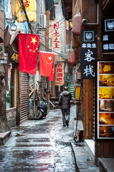 Homem local caminha ao longo de um beco de bares e clubes em Fenghuang, China — Fotografia de Stock