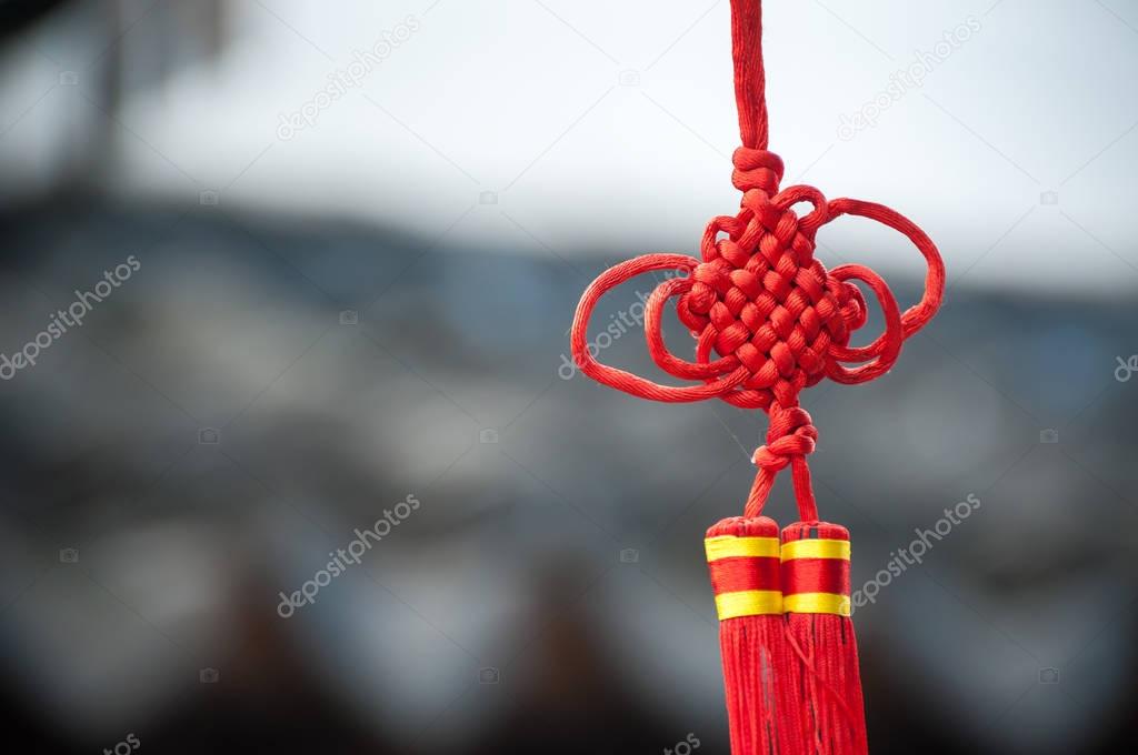 A red Chinese knot decoration hanging in a Suzhou street