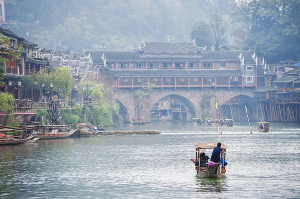 Туристичний човен пролягає вздовж річки Туоцзян до мосту Райдуга в стародавньому місті Фенгуан (провінція Хунань, Китай). — стокове фото
