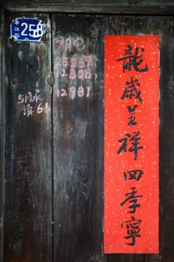 Çin 'de yeni yıl şiiri Pingjiang Yolu, Suzhou, Çin' de eski bir ahşap kapı üzerinde. Pankartta 
