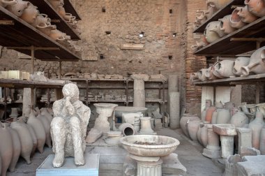 İtalya 'nın Pompeii kentindeki eski Forum Granary' deki kırık çömlekçilikle çevrili Muleteer 'in cesedinin alçı kalıbı.