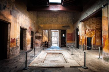 İtalya, Pompei 'deki Menander Hanesi' nin giriş kapısı. Zeminin ortasındaki örtüler çatıdan gelen yağmur suyunu taşımak için tasarlanmıştı..