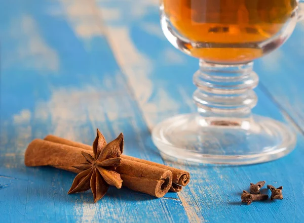 Bir cam kupa mavi ahşap kurullarında baharatlar ile tıbbi çay. 