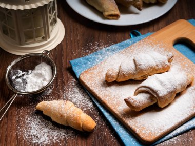 Simit bambu tahtası ile pudra şekeri serpilir