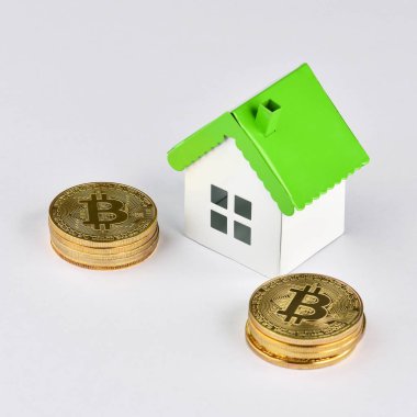 Bitcoin yığınları üzerinde mini model ev. Kriptopara yatırımcıları için kavramsal görüntü (yeni sanal para). Emlak yatırımı ve konut kredisi finansal konsepti