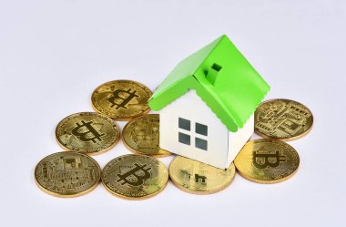 Kriptopara yatırımcıları için kavramsal görüntü (yeni sanal para). Bitcoin yığınları üzerinde mini model ev. Emlak yatırımı ve konut kredisi finansal konsepti